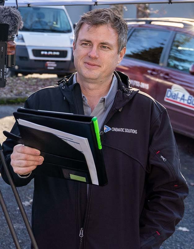 Scott Kemp on location with production notes beside a camera